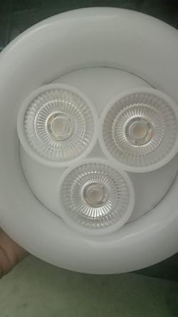 Close-up of a white light fixture with three clear glass covers.

