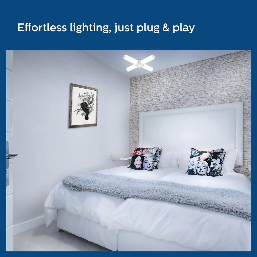 Bedroom with a bed featuring decorative pillows and a light fixture on the wall.

