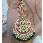 Decorative gold pendant with pearls and gemstones on a hand

