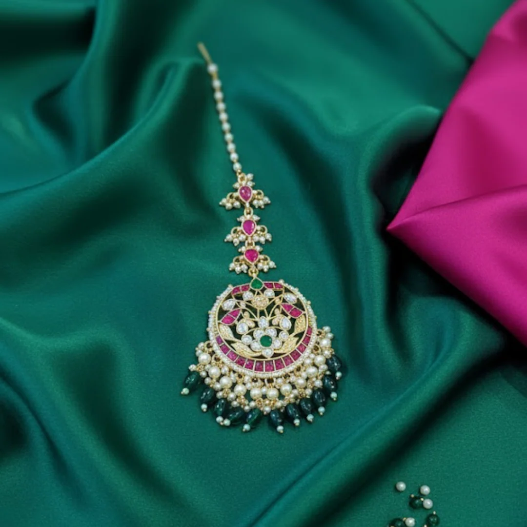 Decorative hairpin with gemstones on a green fabric background

