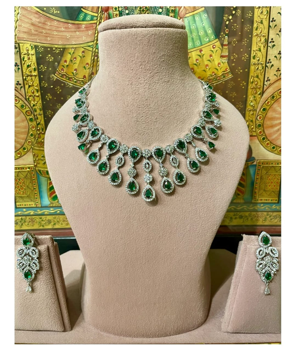 Green and silver necklace on a mannequin bust with matching earrings.