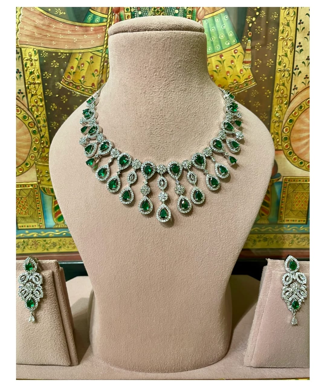 Green and silver necklace on a mannequin bust with matching earrings.