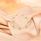 Gold bracelet on a soft peach fabric background


