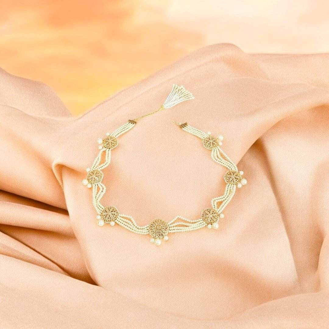 Gold bracelet on a soft peach fabric background

